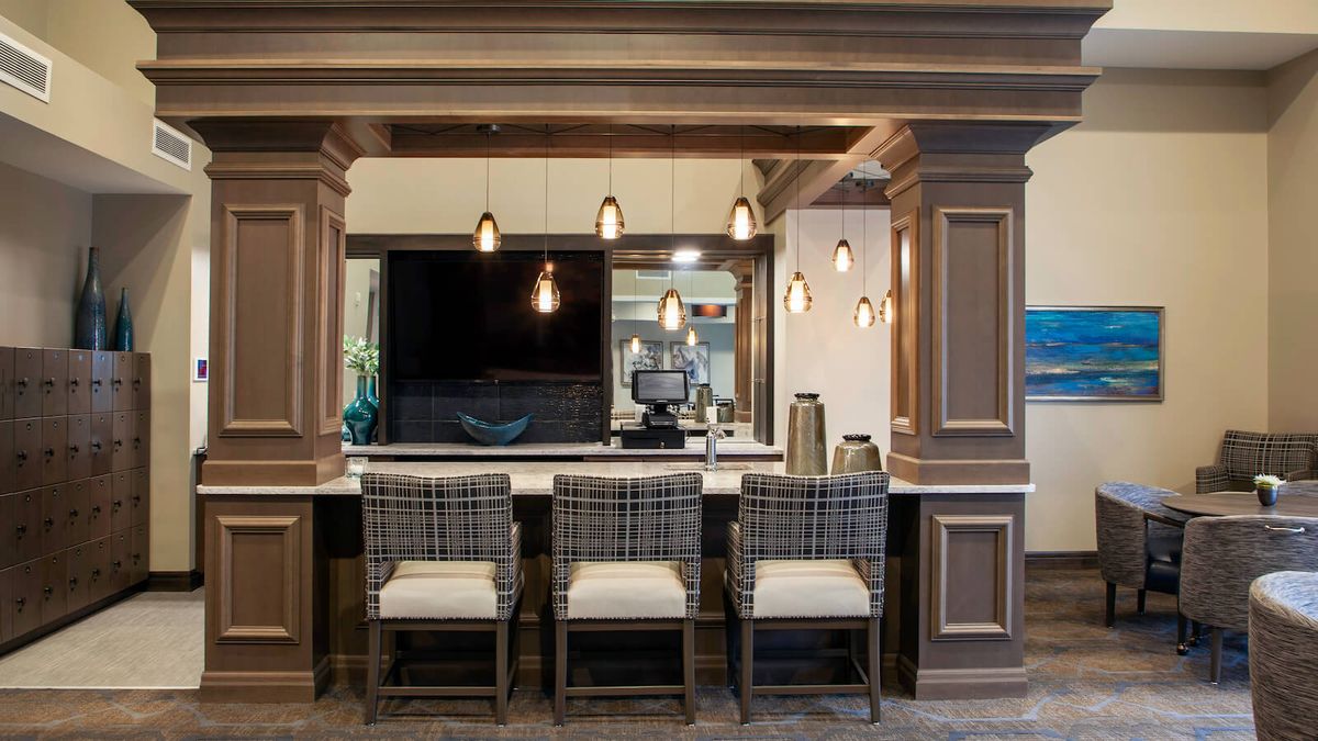 A modern bar area with stylish seating and pendant lighting.