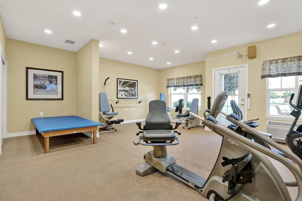 A well-lit exercise room with various fitness equipment.