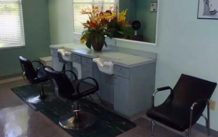 A small salon interior with styling chairs and a mirror.