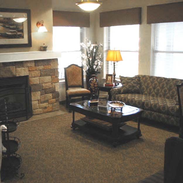 A cozy living room with a sofa, coffee table, and fireplace.