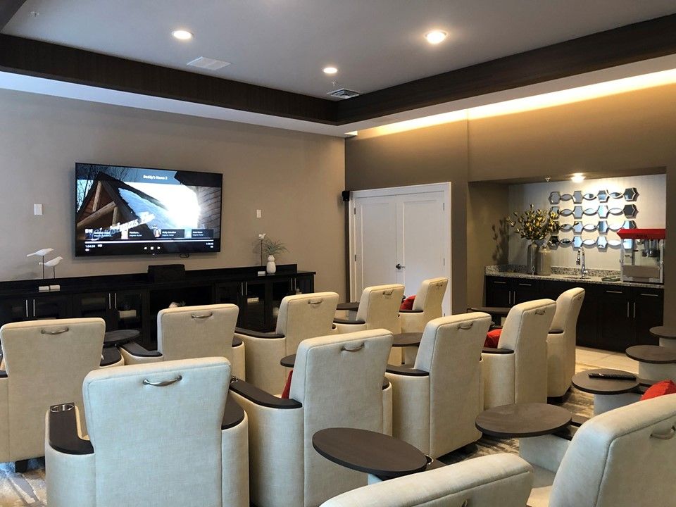A luxurious home theater with comfortable seating and a large screen.