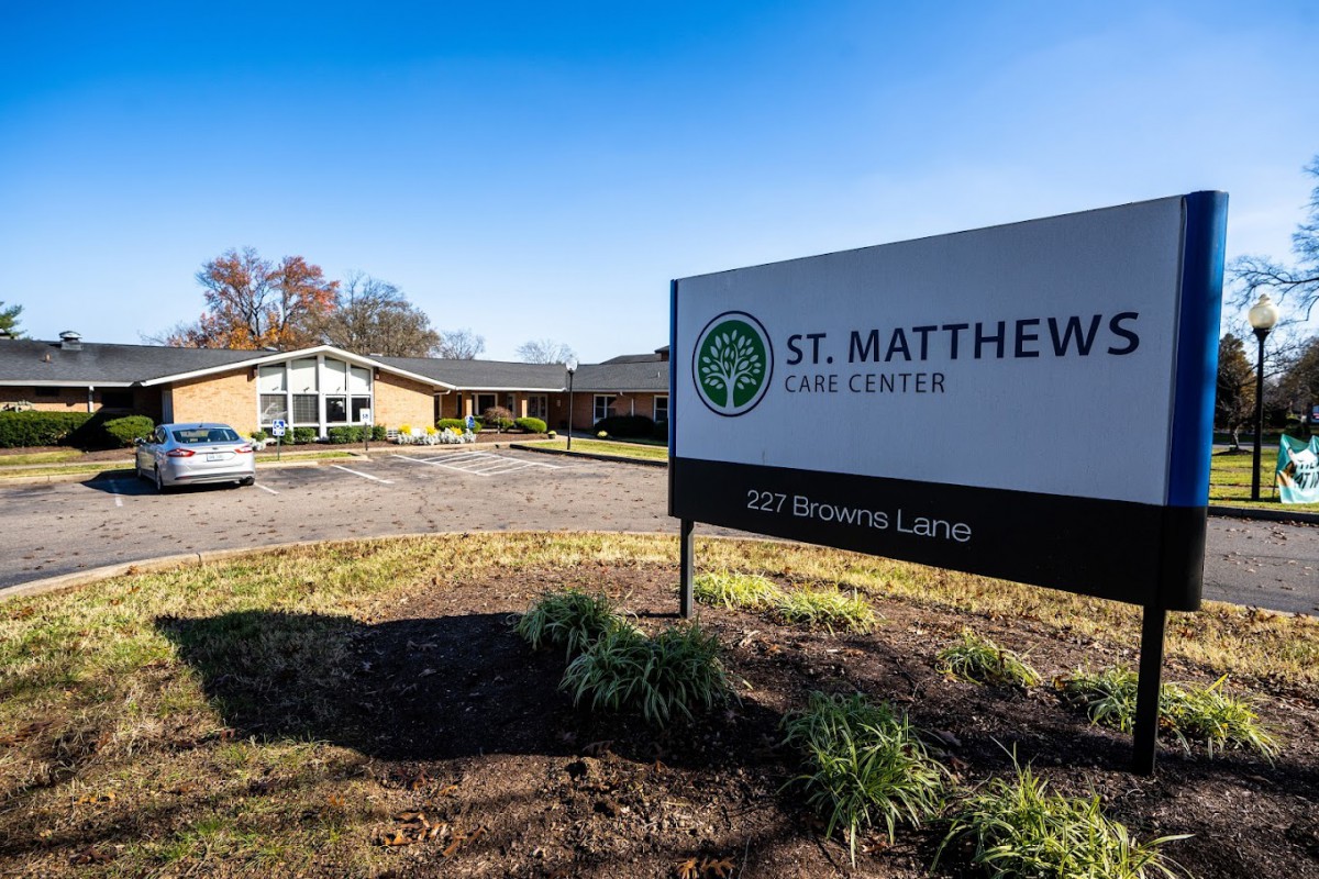 St. Matthew's Episcopal Church with its sign and parking lot on a sunny day.