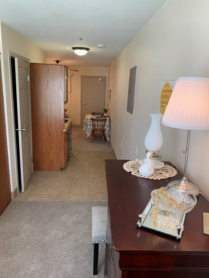 A well-lit hallway with decorative furnishings and a table lamp.