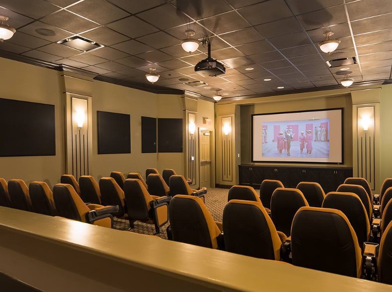 A cozy home theater with comfortable seating and a large projector screen.