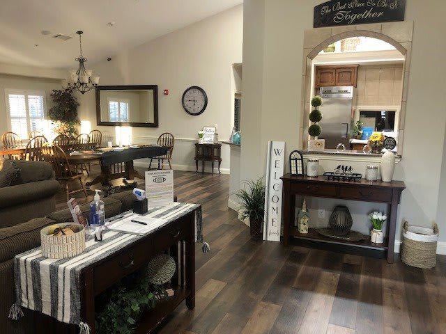 A cozy and well-decorated living and dining area with wooden floors, featuring elegant furniture and warm lighting.
