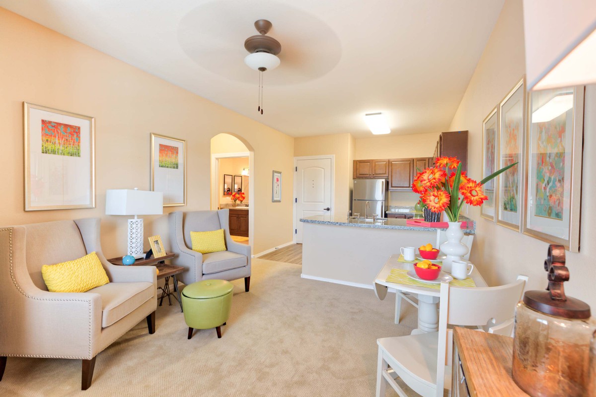 A modern apartment living room with bright decor and an open-concept kitchen.