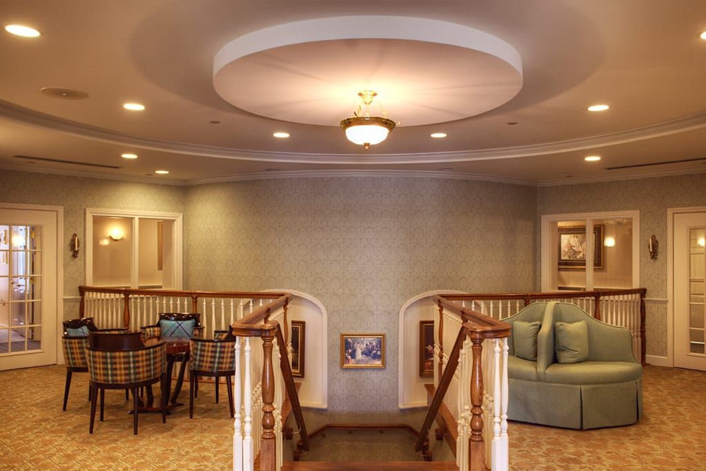 An elegant interior with a central staircase, cozy seating area, and ambient lighting.