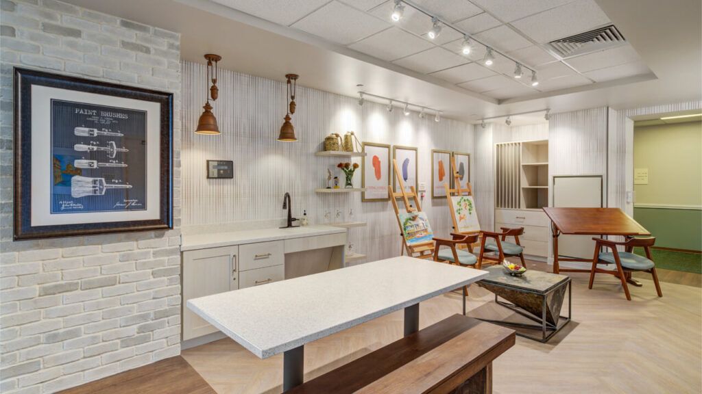 A modern art studio with paintings, workspaces, and stylish lighting.