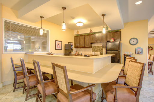 A modern kitchen featuring a spacious dining area with stylish chairs and contemporary appliances.