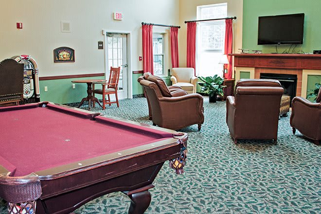 A cozy game room with a pool table and seating area.