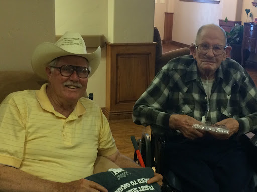 Two elderly men enjoying each other's company in a relaxed indoor setting.