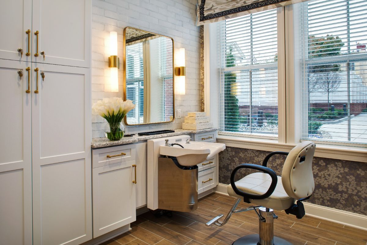 A stylish hair salon interior with a mirror, sink, and comfortable chair.