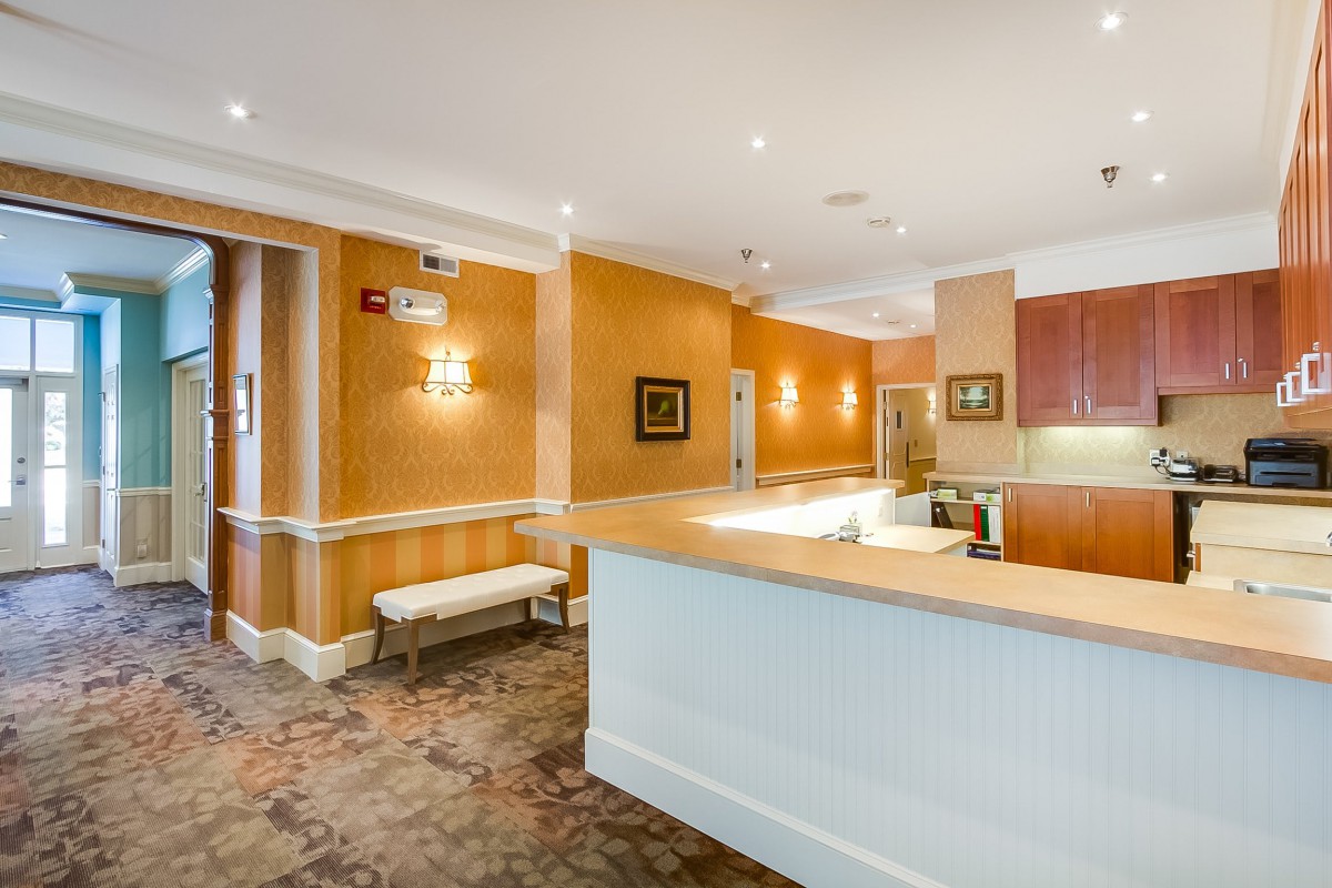 A well-lit reception area with a front desk and seating.
