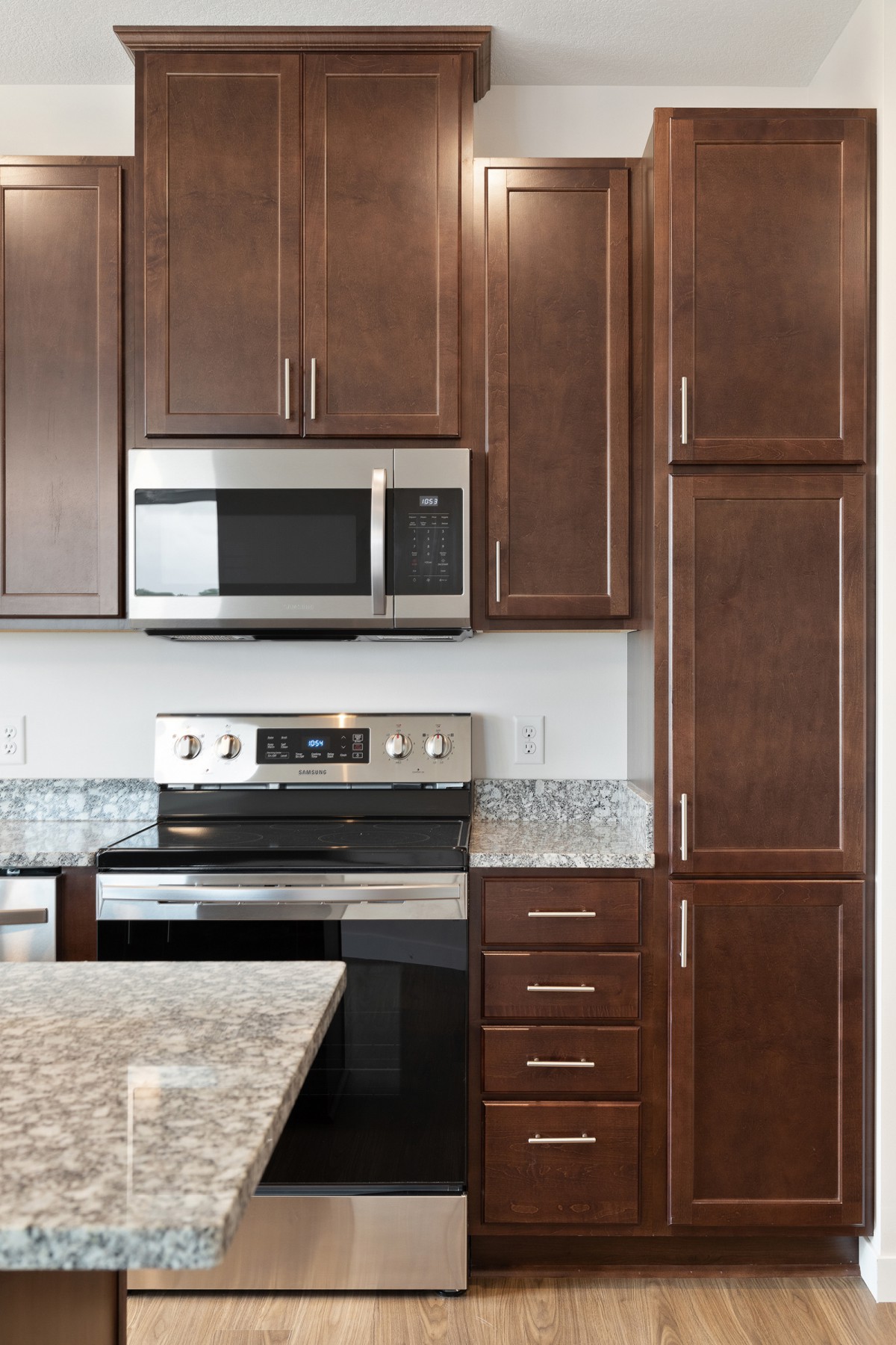 Modern kitchen with stainless steel appliances and dark wood cabinets.