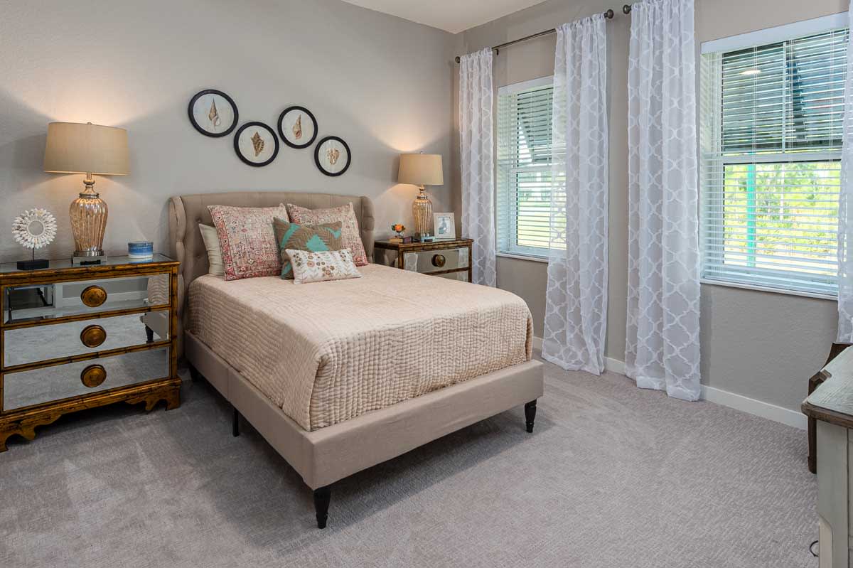 A cozy and modern bedroom with a neatly made bed, decorative pillows, and wall art.