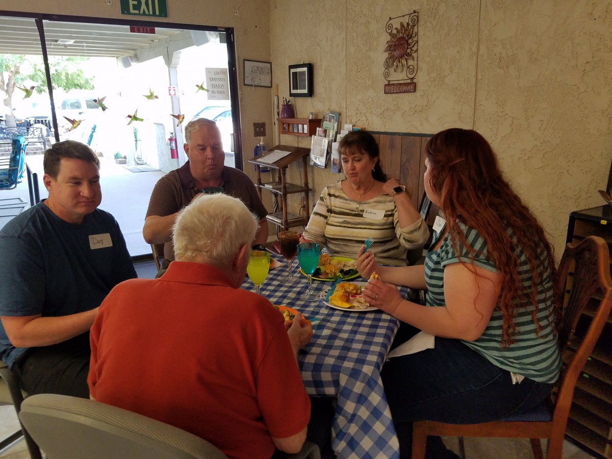 A group of people enjoying a meal together indoors at a table.