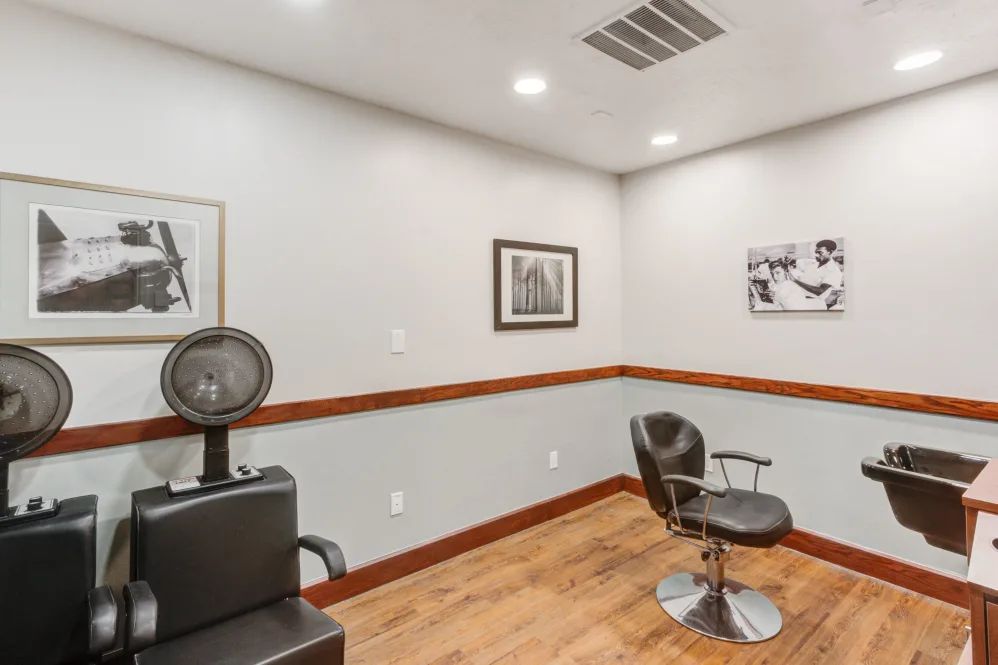 A well-appointed hair salon interior with a styling chair and hair dryer.