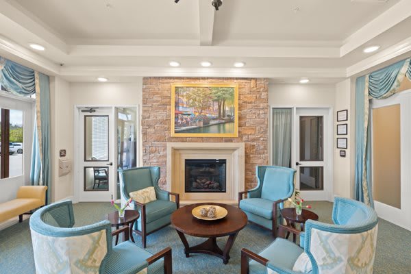 A cozy living room seating area with a fireplace and elegant decor.