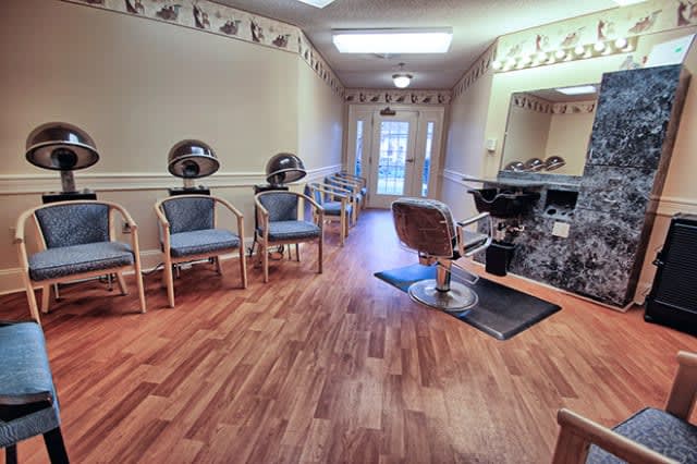 A cozy salon interior with styling chairs and hair drying stations.