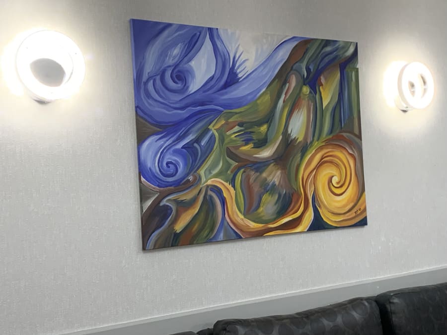 A colorful abstract painting with swirling patterns on a wall.