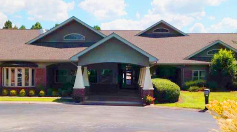 A residential-style building with a covered entrance and a driveway.