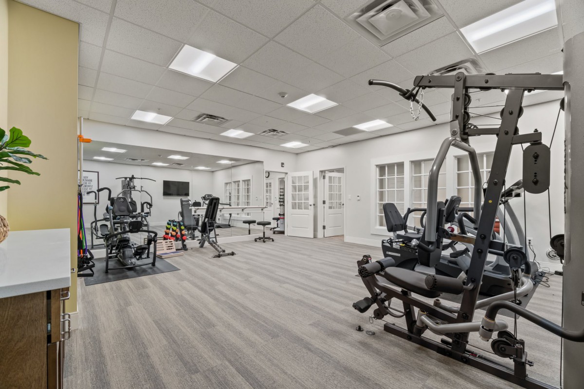 A spacious and well-equipped gym with various exercise machines.