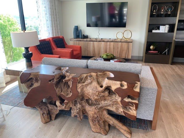 A modern living room featuring a unique wooden table and comfortable seating.