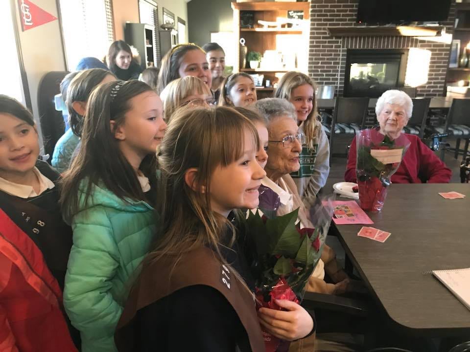 A group of children and adults gathered together indoors, sharing a joyful moment.