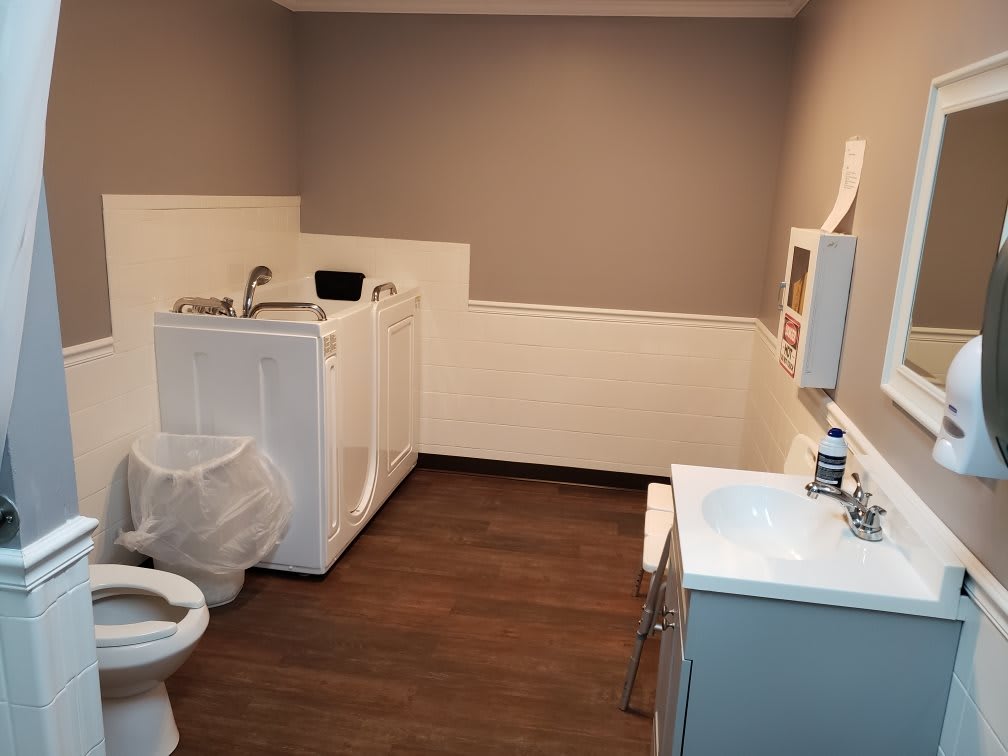A combined bathroom and laundry room featuring a toilet, washing machine, and sink.