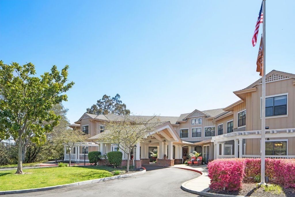 A sunny day view of a residential building with landscaped surroundings.