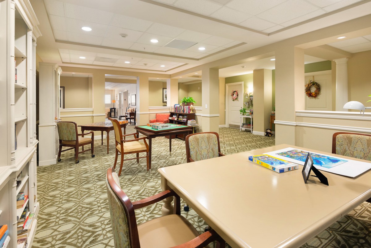 A spacious and well-lit common area with tables and chairs, designed for social gatherings or relaxation.