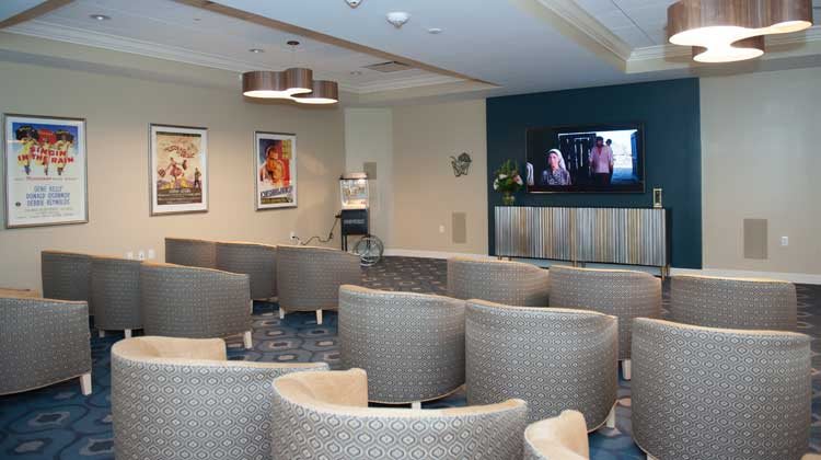 A cozy waiting room with circular seating arrangements and a television on the wall.