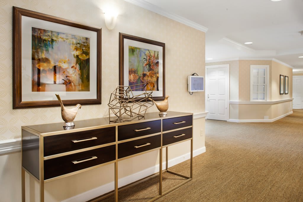 A stylish hallway with a console table, decorative items, and framed artwork on the wall.