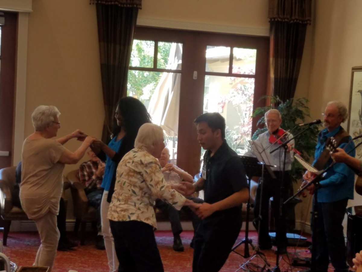 Elderly couples enjoying a dance at a social event with live music.