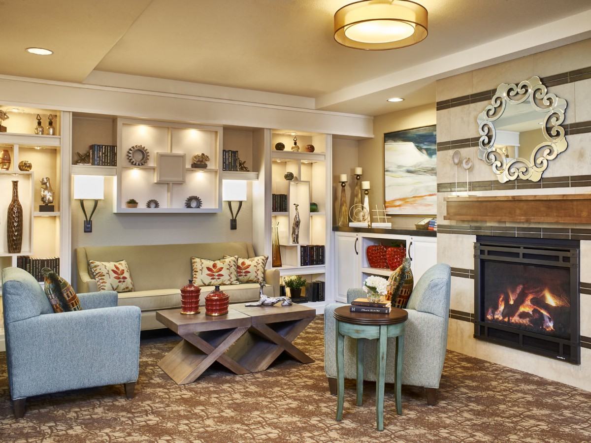 A cozy and elegantly designed living room featuring a modern fireplace, comfortable seating, and stylish decor.