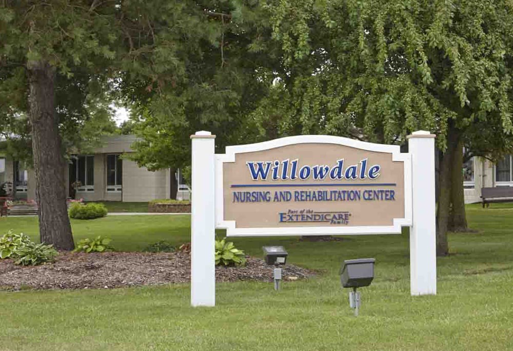 Sign for Willowdale Nursing and Rehabilitation Center surrounded by greenery.