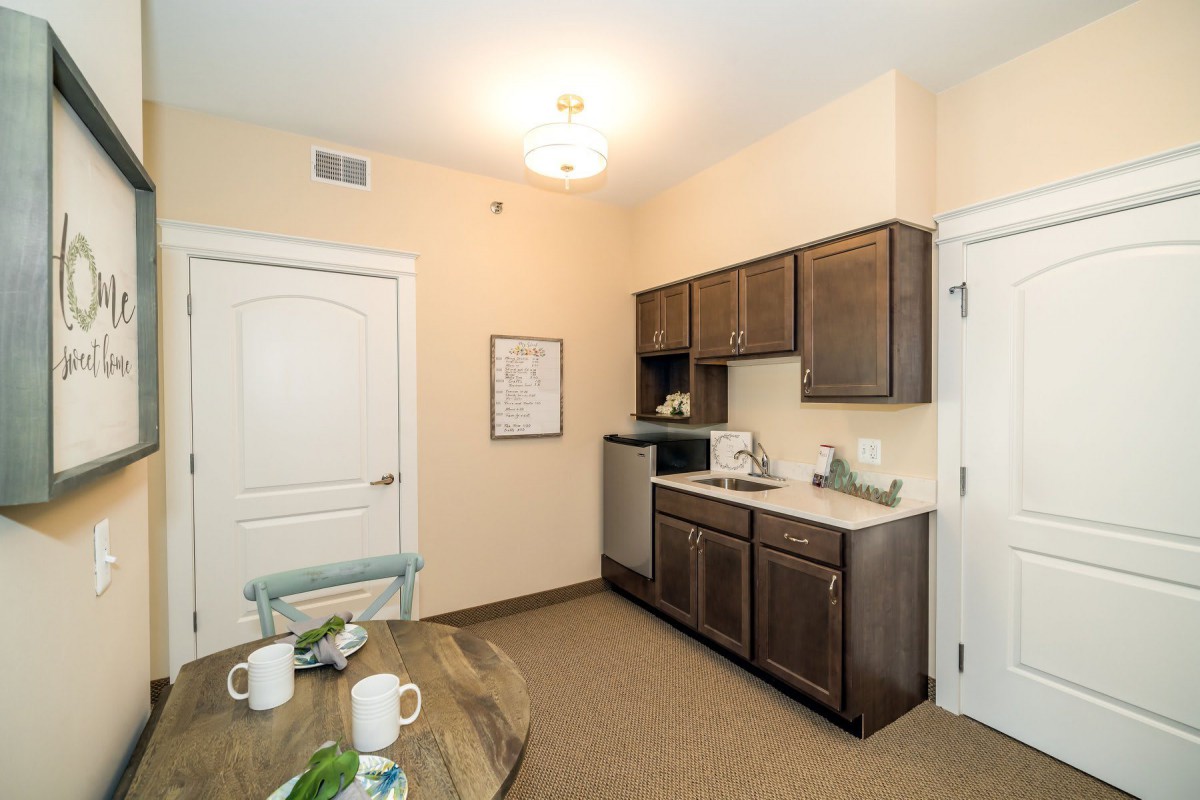Cozy apartment kitchen with modern cabinetry and dining area.