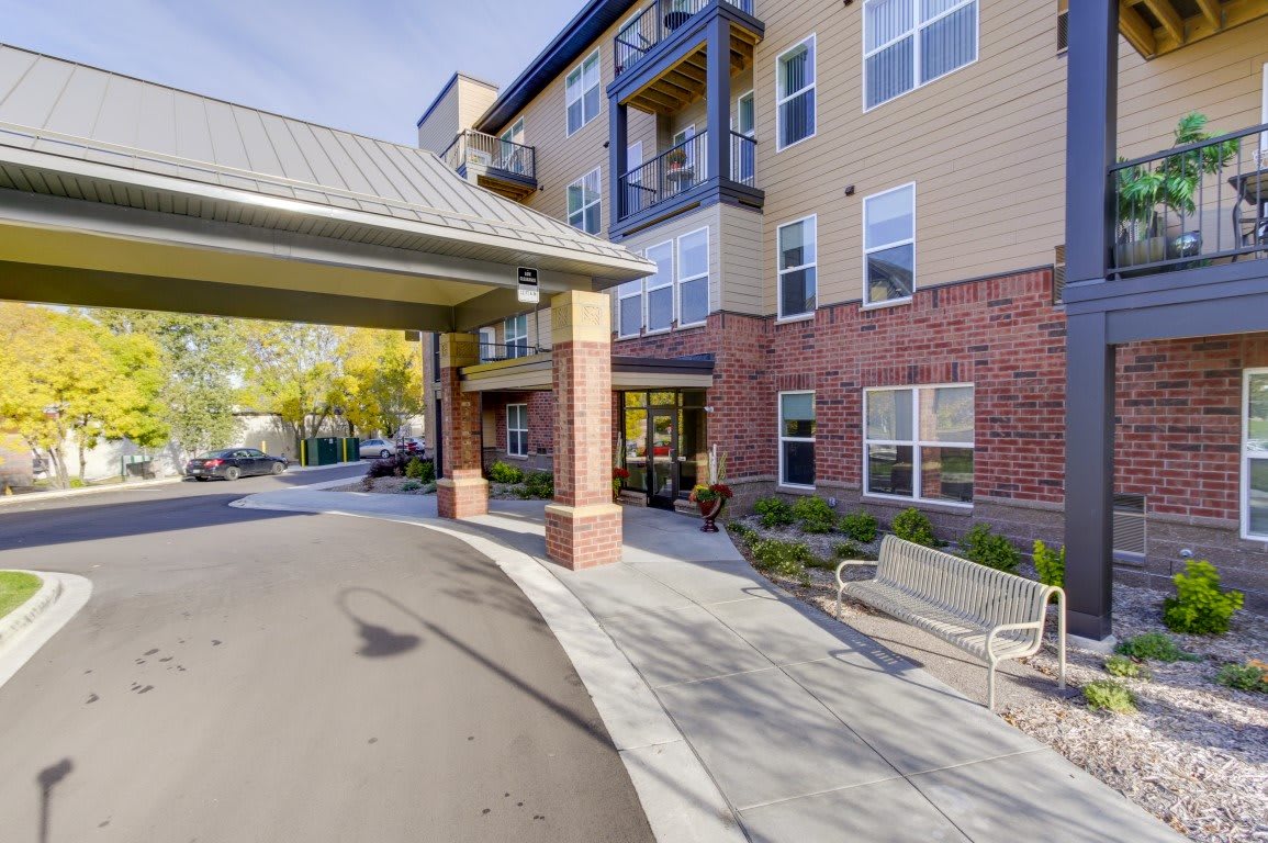 A modern residential building with a welcoming entrance and outdoor seating.