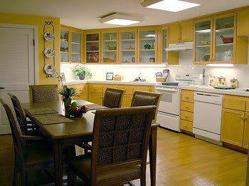 A modern kitchen with wooden cabinets and a dining area.