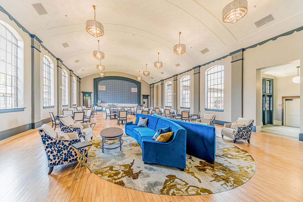 A modern, spacious lounge area with stylish blue sofas and ample natural light.