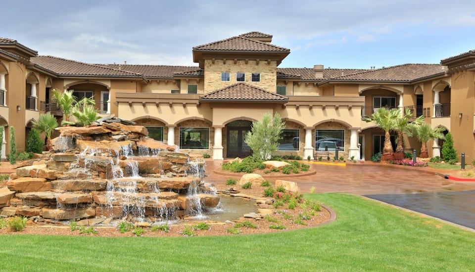 A luxury building with a cascading fountain and landscaped garden.
