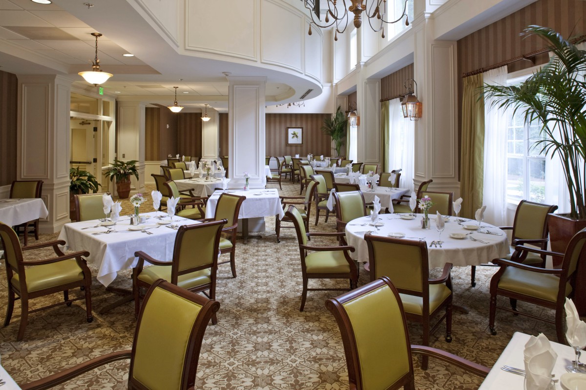 An elegant dining area with neatly arranged tables and chairs in a formal setting.