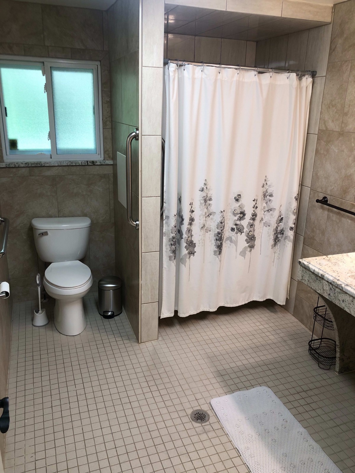 A clean and well-organized bathroom with a toilet, shower area, and sink.