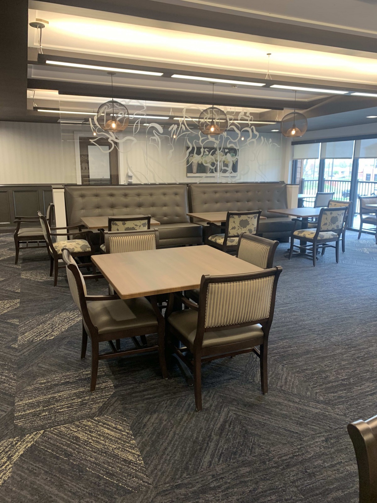 A modern dining area with neatly arranged tables and chairs.