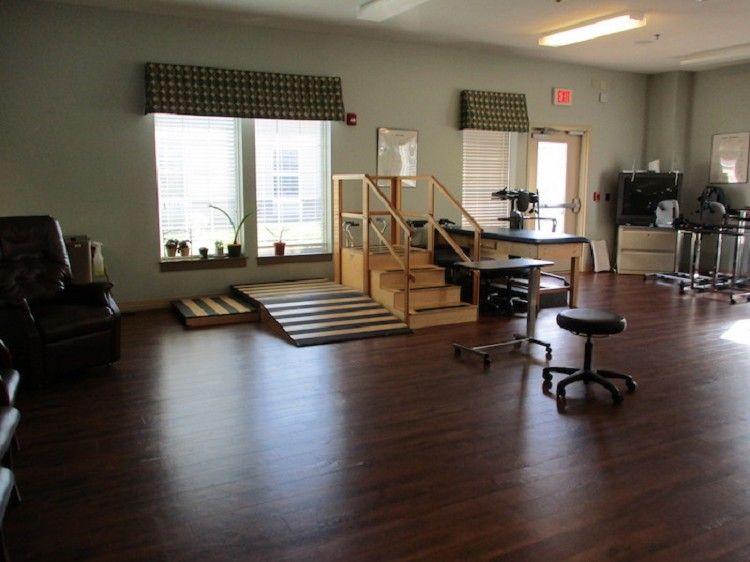 A rehabilitation room equipped with exercise stairs and various physical therapy tools.