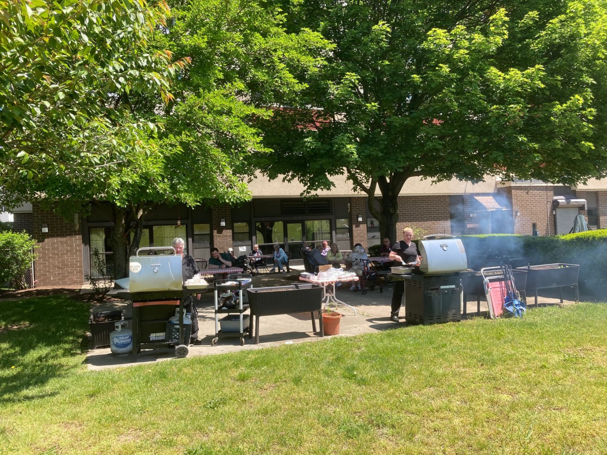 People enjoying a barbecue outdoors on a sunny day.