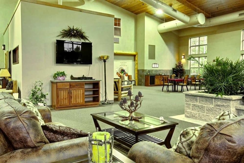 A spacious and modern living room featuring comfortable seating, a wall-mounted television, and tasteful decor.