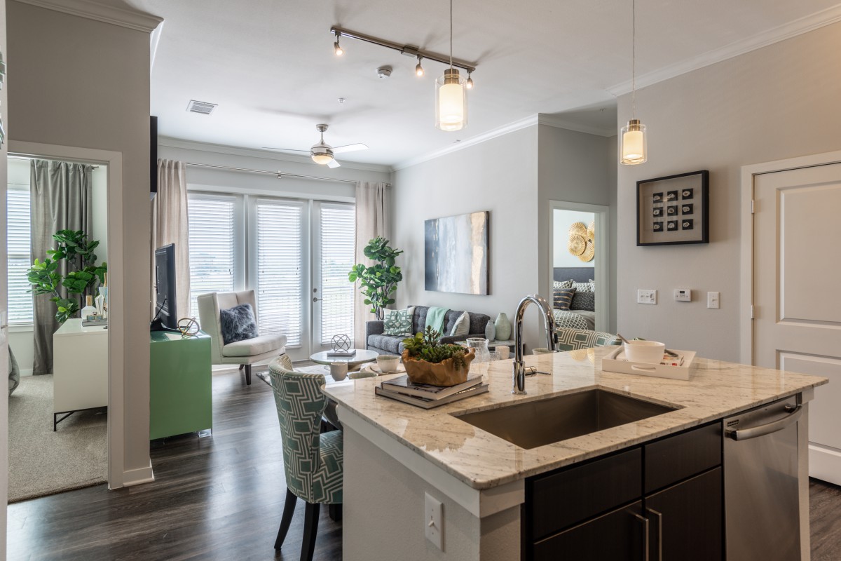 A modern open-plan apartment featuring a stylish kitchen and cozy living room.