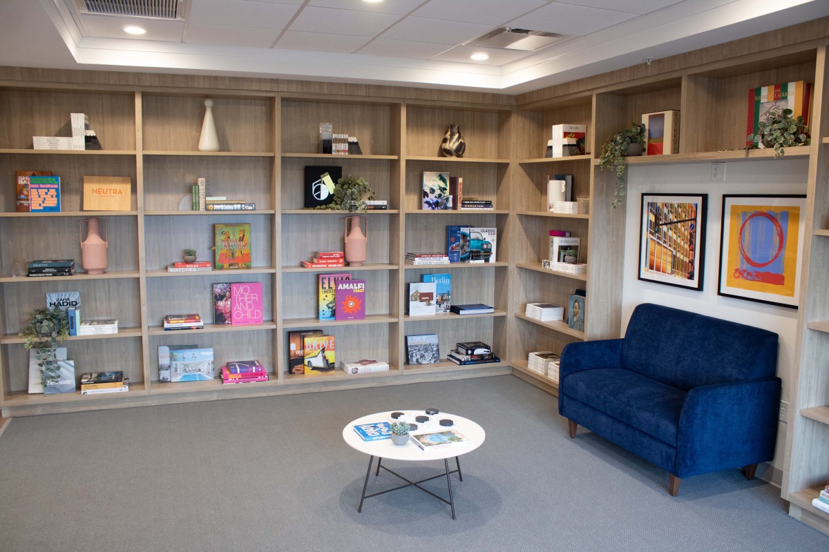 A cozy reading nook featuring modern bookshelves and a comfortable armchair.