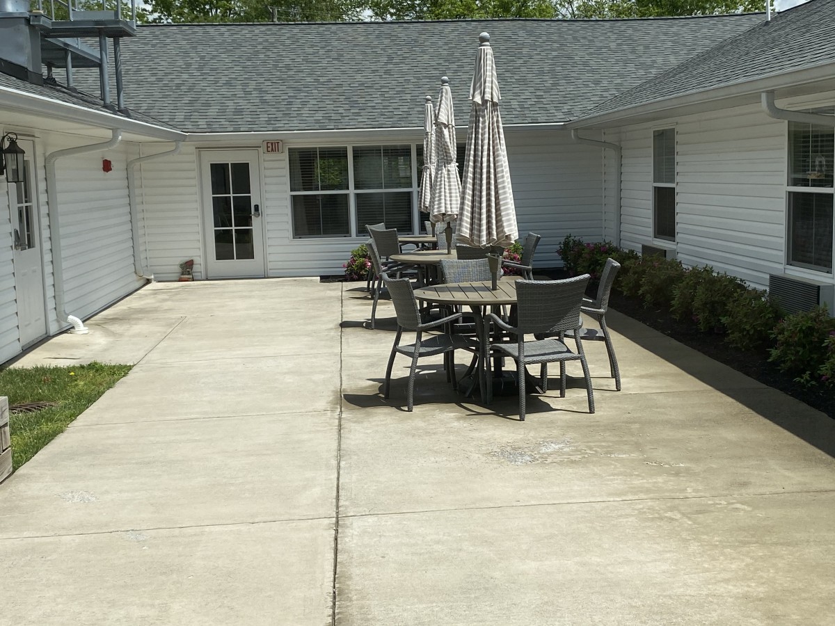 An outdoor patio area with tables and chairs under umbrellas.